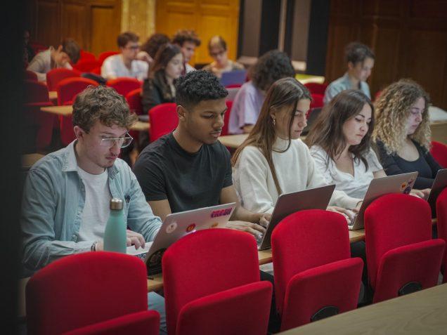 Des étudiants en amphithéâtre prennent nots lors d’un cours du Master Expertise Internationale